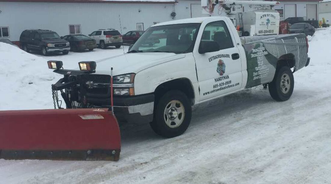 Extraordinaire's branded plow truck clearing snow in Sioux Falls